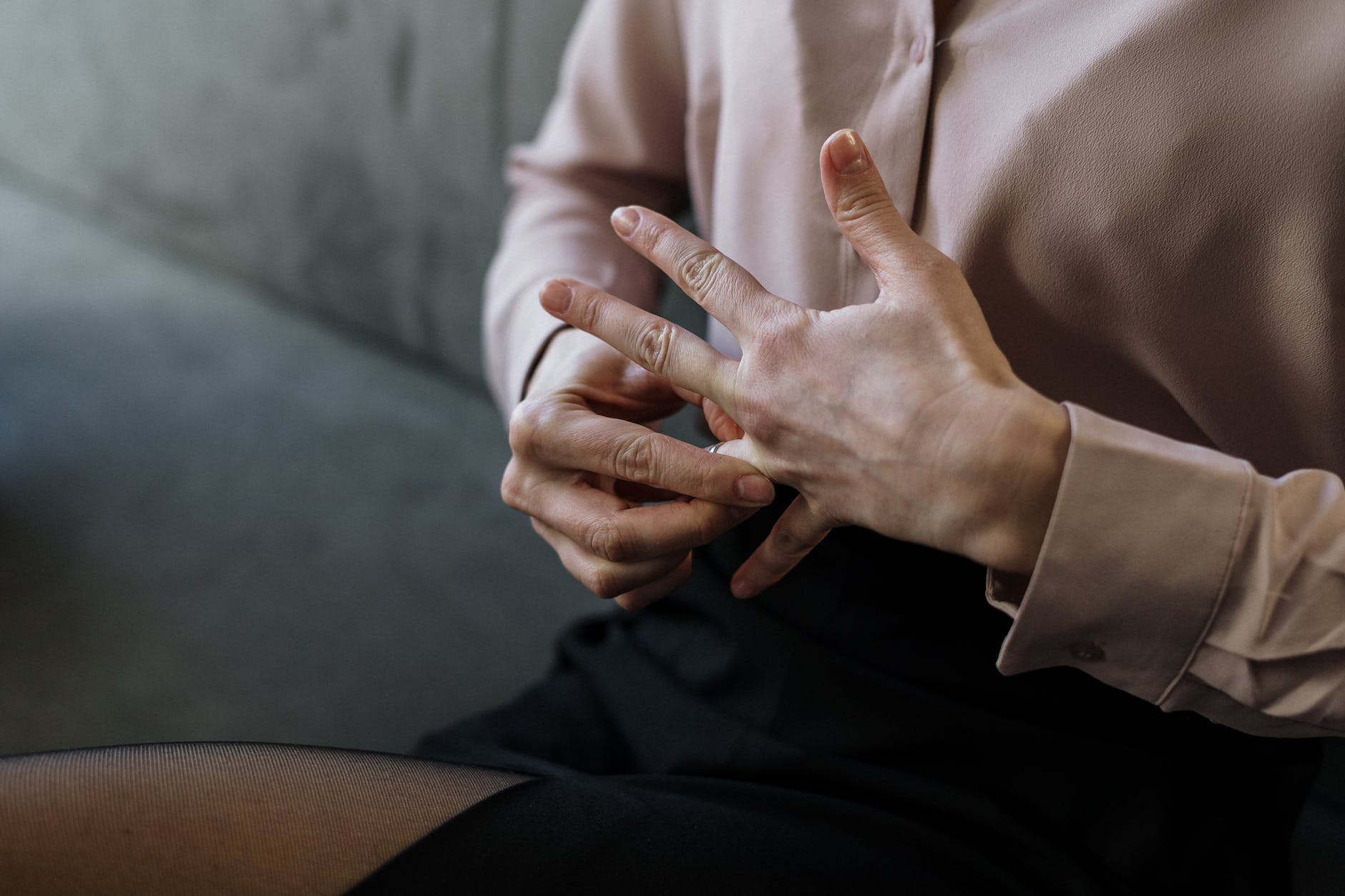 Kobieta nerwowo dotykająca się za palec serdeczny lewej dłoni w geście manipulacyjnym. Photo by cottonbro studio on Pexels.com